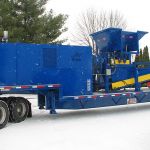 30 series quad-shaft hydrostatic shear shredder with an outfeed conveyor and collection container