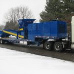 30 series quad-shaft hydrostatic shear shredder with an outfeed conveyor and collection container